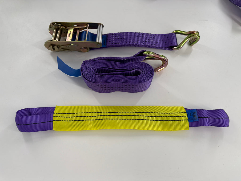 Purple webbed lifting strap with metal hooks and a ratchet buckle, shown on a white background.