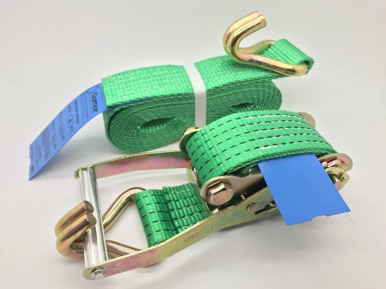 Green ratchet straps tie down with metal hooks and ratchet mechanism for securing cargo
