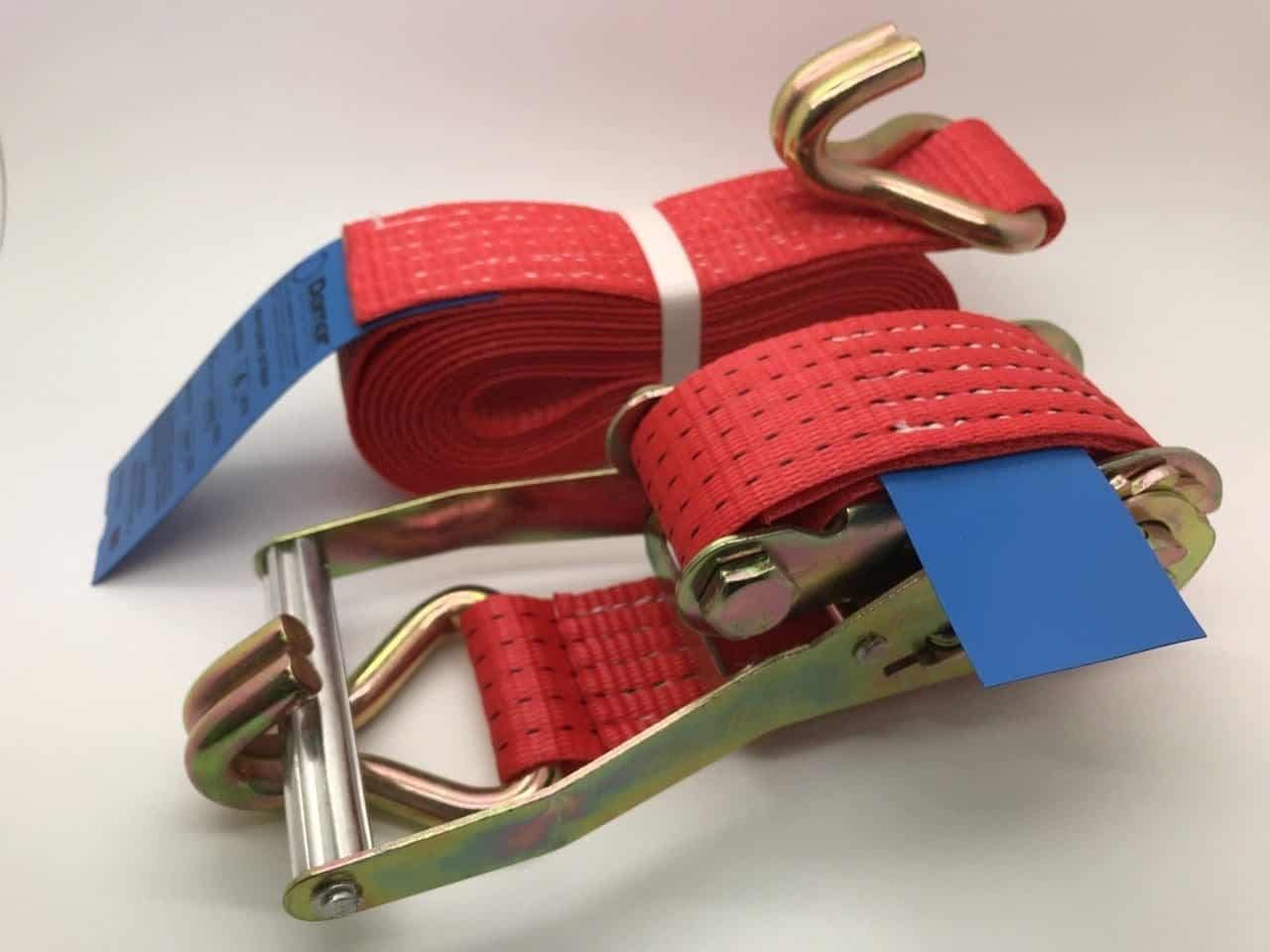 Red ratchet straps tie down with metal hooks and ratchet mechanism for secure cargo fastening